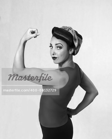 woman brunette in a blue shirt with a scarf on her head and hair in a retro style biceps show-off