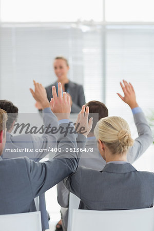Business team raising hands during conference in meeting room