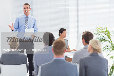 Smiling businessman talking during conference in meeting room