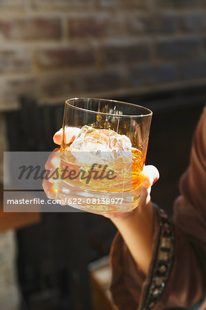 Young Japanese woman with glass of whiskey in a fashionable bar