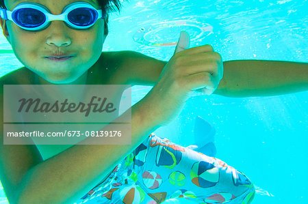 Underwater view of a boy swimming wearing goggles