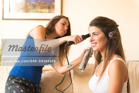 Young woman doing friend's hair