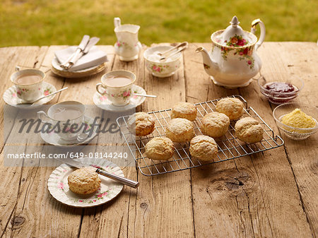 Table with afternoon tea of with fresh baked scones with jam and clotted cream
