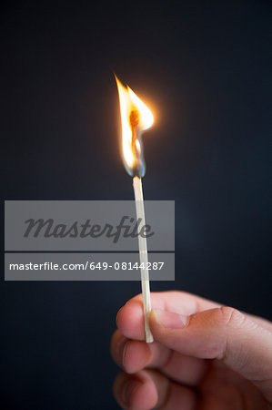 Person holding burning match
