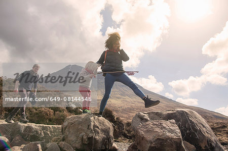 Family walking over boulders, Fair Pools, Isle of Skye, Hebrides, Scotland