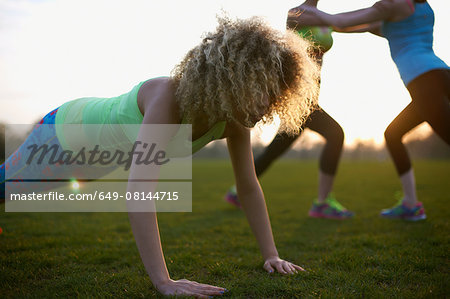 Portrait of woman doing push up exercise in park