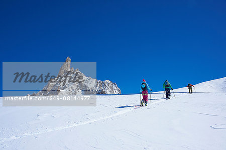 Rear view of three skiers moving up Mont Blanc massif, Graian Alps, France