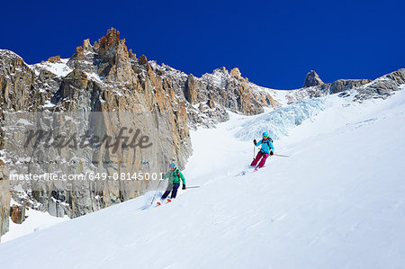 Male and female skiers skiing down Mont Blanc massif, Graian Alps, France