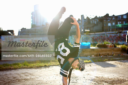 Young women doing upside down breakdancing freeze, looking at camera