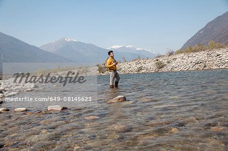 Young male hiker looking out from Toce river, Vogogna, Verbania, Piemonte, Italy