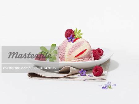 A raspberry ice cream bomb with raspberries, woodruff and flowers