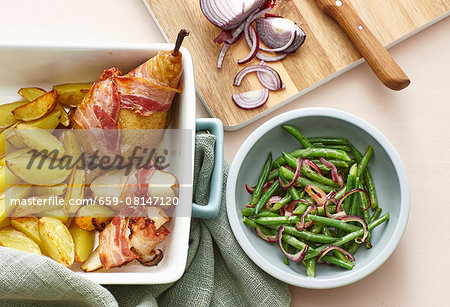 Bacon-wrapped pears with roast potatoes and a bean and onion salad