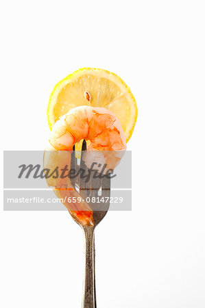 A prawn and a slice of lemon on a fork A prawn and a slice of lemon on a fork