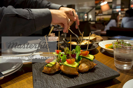 Chicken breast skewers with courgettes and cherry tomatoes in a restaurant