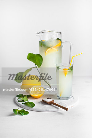 Homemade lemonade with lemons and a wooden spoon of sugar Homemade lemonade with lemons and a wooden spoon of sugar