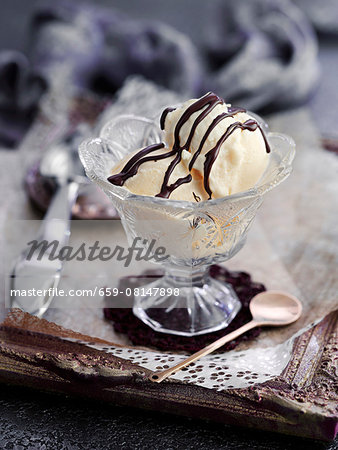 Vanilla ice cream with chocolate sauce in a crystal glass