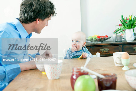 Father and baby boy at breakfast table