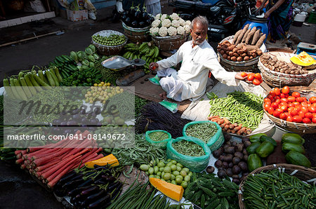 Subji wallah (vegetable seller) sitting at his beautifully laid out vegetable stall in the market, Ahmedabad, Gujarat, India, Asia