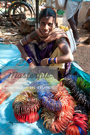 Young woman with ropes of coloured bangles for sale in Mali weekly tribal market, Guneipada, Koraput district, Orissa (Odisha), India, Asia