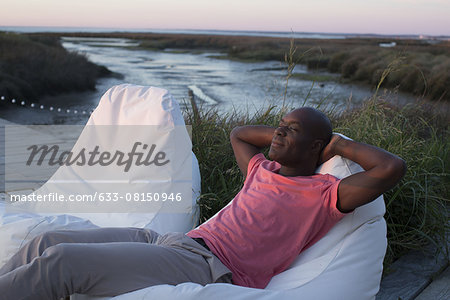 Man relaxing at water's edge
