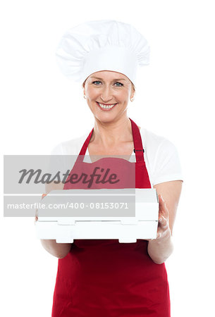 Female baker presenting pizza to you in a packed box. Enjoy your meal