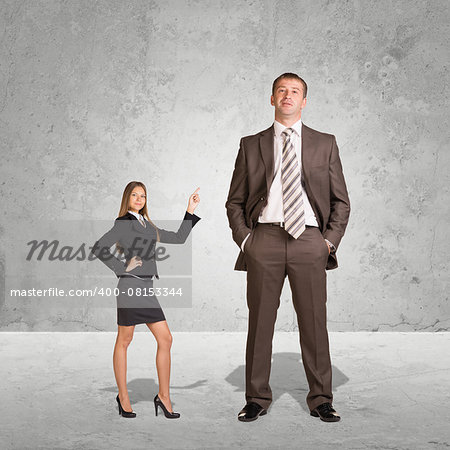 Small Young Businesswoman and Large Businessman. Concrete background