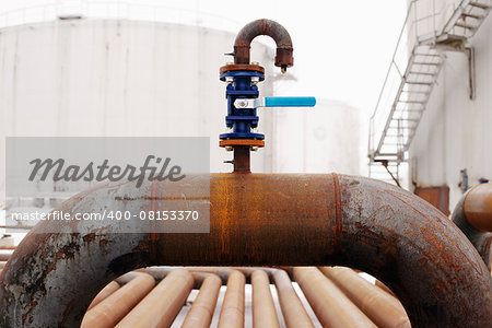 Oil and gas pipeline valve on rusty piping