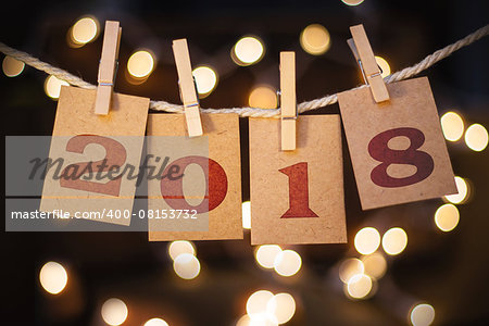 The word 2018 spelled out on clothespin clipped cards in front of glowing lights.