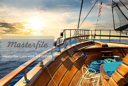 Wooden sailboat in the sea at sunrise