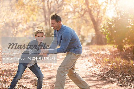 Playful father and son on path in woods