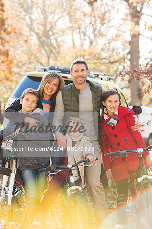 Portrait smiling family with mountain bikes outdoors