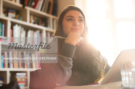 Pensive teenage girl with digital tablet