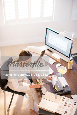 Interior designer examining carpet swatches at desk