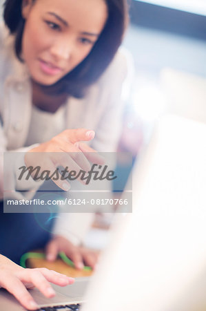 Focused businesswoman pointing at laptop