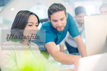 Creative business people using laptop in office