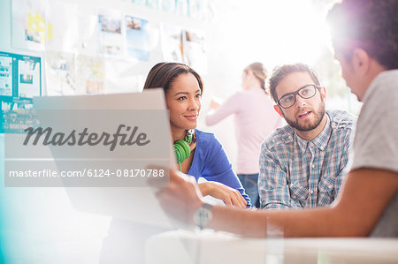 Creative business people discussing paperwork in office Creative business people discussing paperwork in office