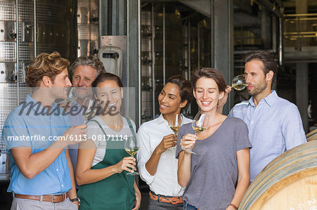 Winery employees tasting white wine in cellar