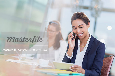 Businesswoman talking on cell phone and using digital tablet in office