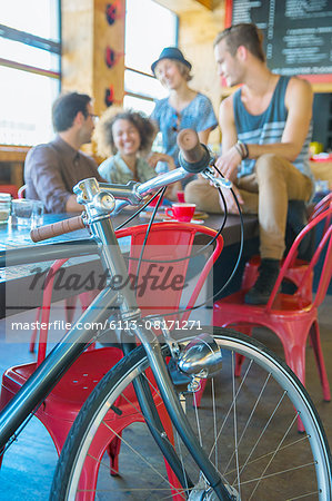 Friends hanging out at cafe behind bicycle