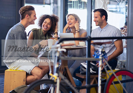 Friends hanging out in cafe behind bicycle
