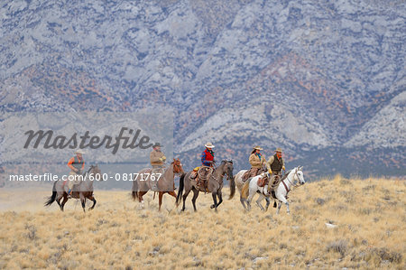 Cowboys and Cowgirls riding horses in wlderness, Rocky Mountains, Wyoming, USA