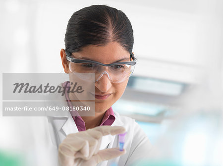 Female scientist viewing sample in eppendorf ahead of DNA testing in a laboratory.