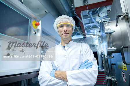 Portrait of male scientist with arms crossed in lab cleanroom