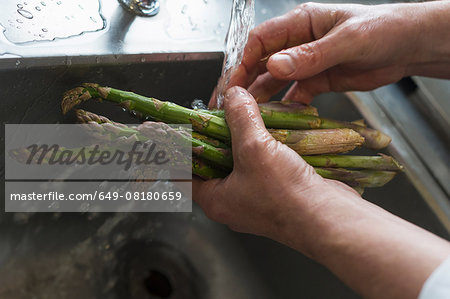 Washing asparagus, focus on hands