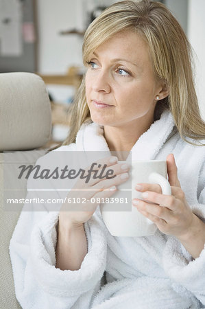 Woman in bathrobe holding mug