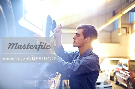 Mechanic working on car in auto repair shop