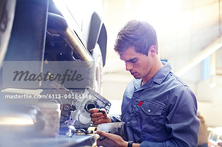 Mechanic examining part in auto repair shop