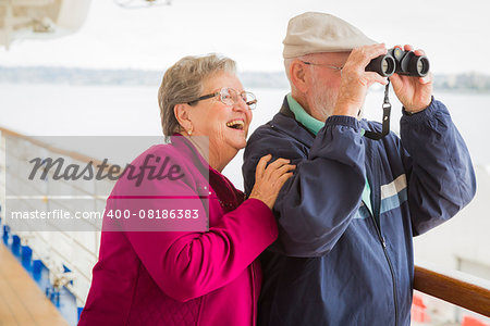 Happy Senior Couple Enjoying The View From Deck of a Luxury Passenger Cruise Ship.