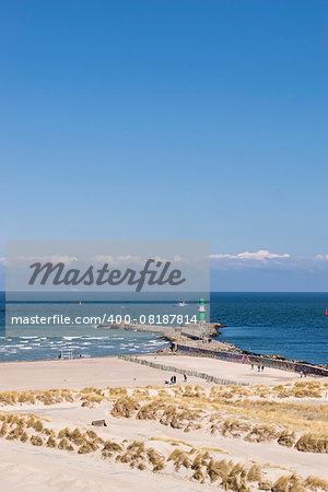 Beach of Warnemunde Germany with lighthouse on the Baltic Sea and blue sky with free space