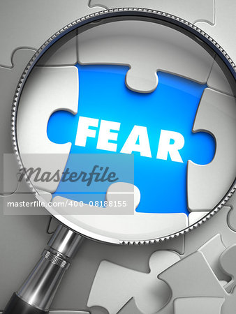 Fear - Word on the Place of Missing Puzzle Piece through Magnifier. Selective Focus.